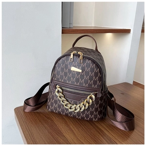 Detail view of brown monogram backpack with gold chain accent and double zipper texture