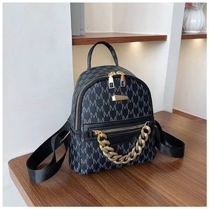 Detail of black mini backpack featuring grey M-pattern jacquard and gold metal chain