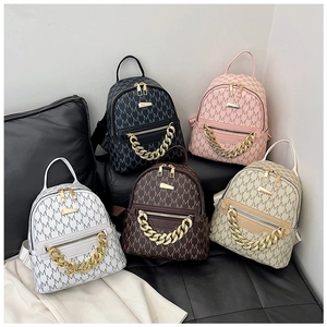Detail of five mini backpacks featuring jacquard M pattern and gold metal chain decor