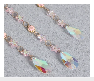 Detailed view of pink resin stars, floral charms and faceted AB coated crystal droplets