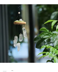 Detail of natural white crystal wind chime with wood base and moss for garden decor