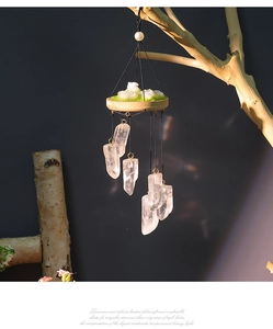 Detailed view of raw natural white crystal stones and mossy wooden base wind chime