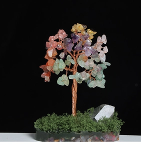 Detail of colorful crystal money tree with copper wire trunk and natural stone base