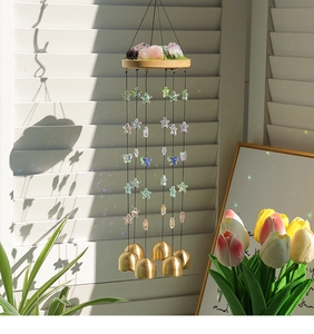 Détail d'un carillon bohème avec cristaux naturels, pendentifs étoiles et cloches
