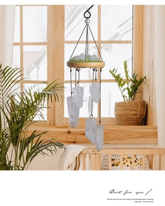 Detail of natural crystal stone wind chime hanging on a balcony with wooden base