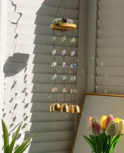 Detail eines Amethyst-Windspiels mit Holzscheibe, bunten Sternperlen und Messingglocken