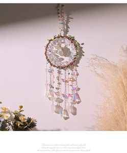Close-up of tree of life dreamcatcher with crystals casting light shadows on wall