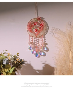 Detail of pink flower heart dreamcatcher with rainbow crystal pendants and gold ring