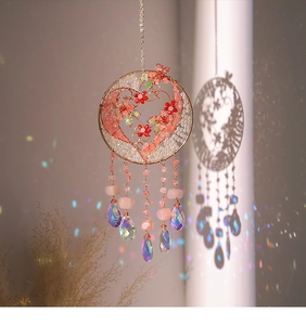 Detail of tree of life suncatcher with pink crystals and rainbow glass prism pendants