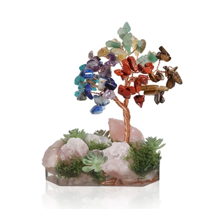 Chakra money tree with colorful natural crystals and rose quartz base on a tray