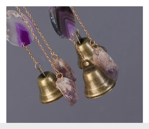 Dettaglio di campana in bronzo vintage con fetta di agata viola e cristallo grezzo