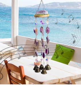Λεπτομέρεια από boho μενταγιόν αμέθυστου με κρύσταλλα και χάλκινα κουδούνια σε εξωτερικό χώρο