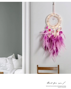 Detail eines rosa Traumfängers mit LED-Beleuchtung und hängenden Federn für Deko