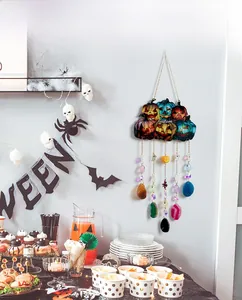 Halloween pumpkin pendant with colorful stones hanging in a festive party scene