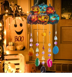 Close-up of Halloween stained glass hanging with pumpkin heads and agate slices