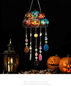 Macro detail of stained glass Halloween pumpkin pendant with hanging gems and beads