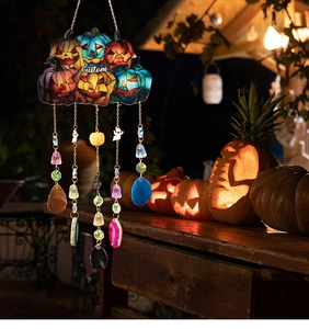 Detailed view of Halloween pumpkin suncatcher with ghost charms and crystals