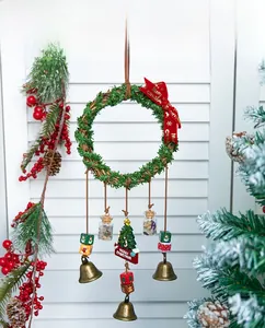 Close-up of Christmas wreath ornament with metal bells, bow, and stone bottle detail