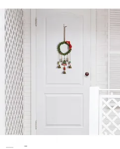 Detail of a Christmas wreath door hanging with bells and Merry Christmas sign on a door