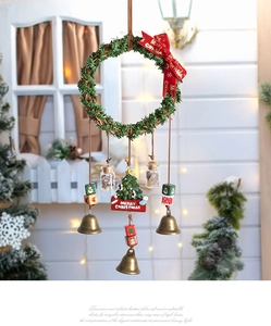 Detailed view of a Christmas wreath ornament with vintage bells and red ribbon on wood