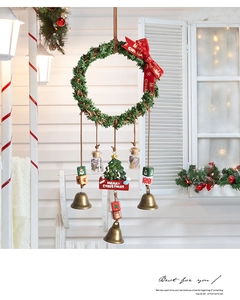 Close-up of a Christmas wreath wind chime with bells and Merry Christmas sign