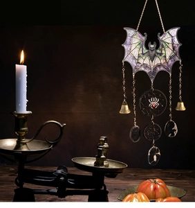 Macro detail of gothic acrylic bat suncatcher with colored glass and hanging stone charms