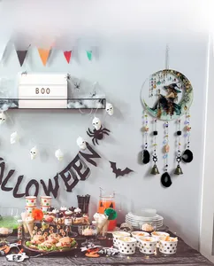 Détail de décoration murale d'Halloween avec croissant de lune, sorcière et cloches en bronze