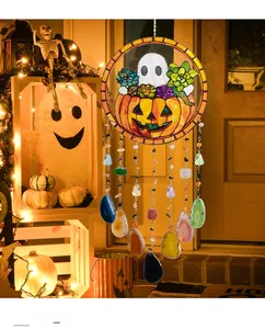 Detail of Halloween wind chime with pumpkin ghost glass pendant and agate slices on a porch
