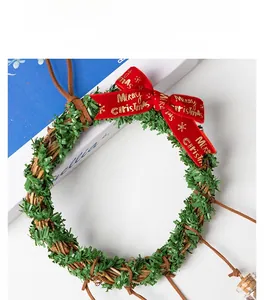 Detail of a Christmas wreath with a rattan base, green needles and a red velvet bow