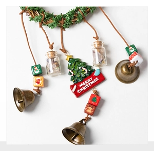 Detail of Christmas wreath hanger with bronze bells, glass jars and Merry Christmas sign