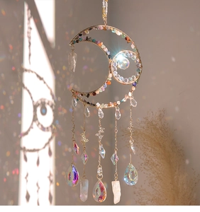 Artistic shadow play showing a golden moon suncatcher with colorful crystals and butterflies