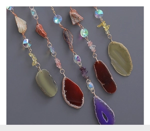 Detailed view of colorful natural agate slices and crystal tree of life wind chime hanging