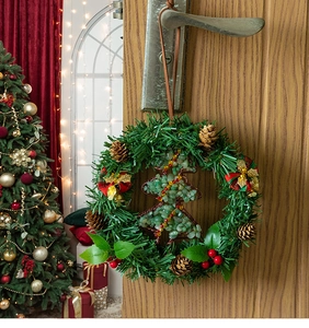 Christmas wreath detail with green stone tree, pine cones and festive red plaid bow