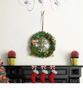 Detail of Christmas wreath with pine cones, red berries and a green metal tree outline