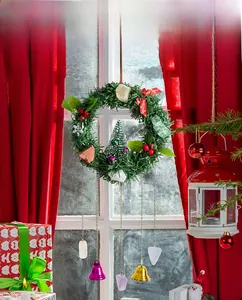 Christmas wreath with green pine needles red berries and colorful bells for door decor