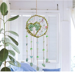 Macro detail of tree of life dream catcher with green crystals and butterfly pendants
