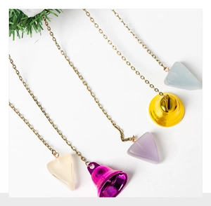 Close-up of colorful bell ornaments with frosted pendants and metal chains for decoration