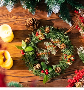 Close-up of a Christmas wreath featuring pine needles, red berries, and gemstone pendants