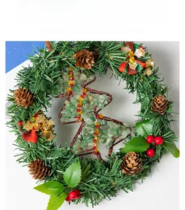 Close-up of Christmas wreath with pine cones, red bow, and green stone tree charm