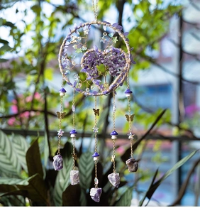 Detail of tree of life dreamcatcher with purple crystals and hanging butterfly charms