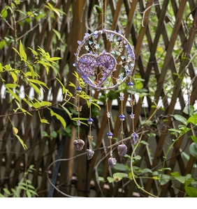 Detail of heart-shaped Tree of Life dream catcher with purple crystal stones and charms