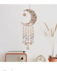 Macro detail of crescent moon suncatcher with tree of life and crystal drop beads