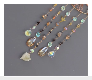 Detailed shot of golden tree of life suncatcher with hummingbird and crystal prism drops