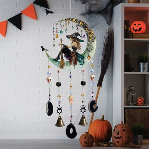 Carillon sorcière d'Halloween avec pierres noires et cloches sur un mur blanc