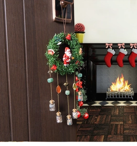 Close-up of a Christmas wreath hanger with Santa, natural stones, and a tiny glass wish bottle