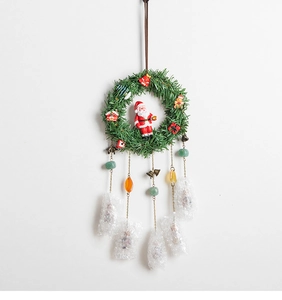 Detail of Christmas wreath with Santa Claus figurine and festive charms on hanging chains