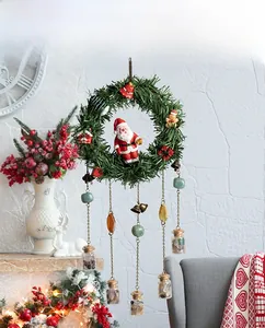 Detail of Christmas wreath with Santa figurine, metal bells and small glass stone bottles