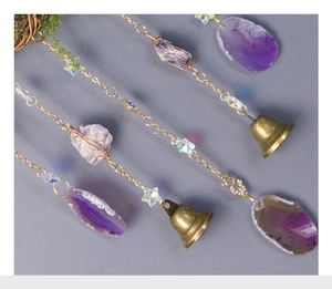 Detail of tree of life wind chime with purple agate slices and golden bells