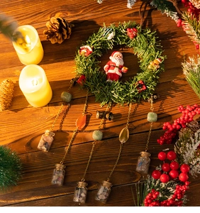 Detail of Christmas wreath with Santa figurine and dangling glass vials with colorful stones