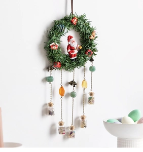 Detailed view of Christmas wreath chime with natural crystal bottles and festive ornaments